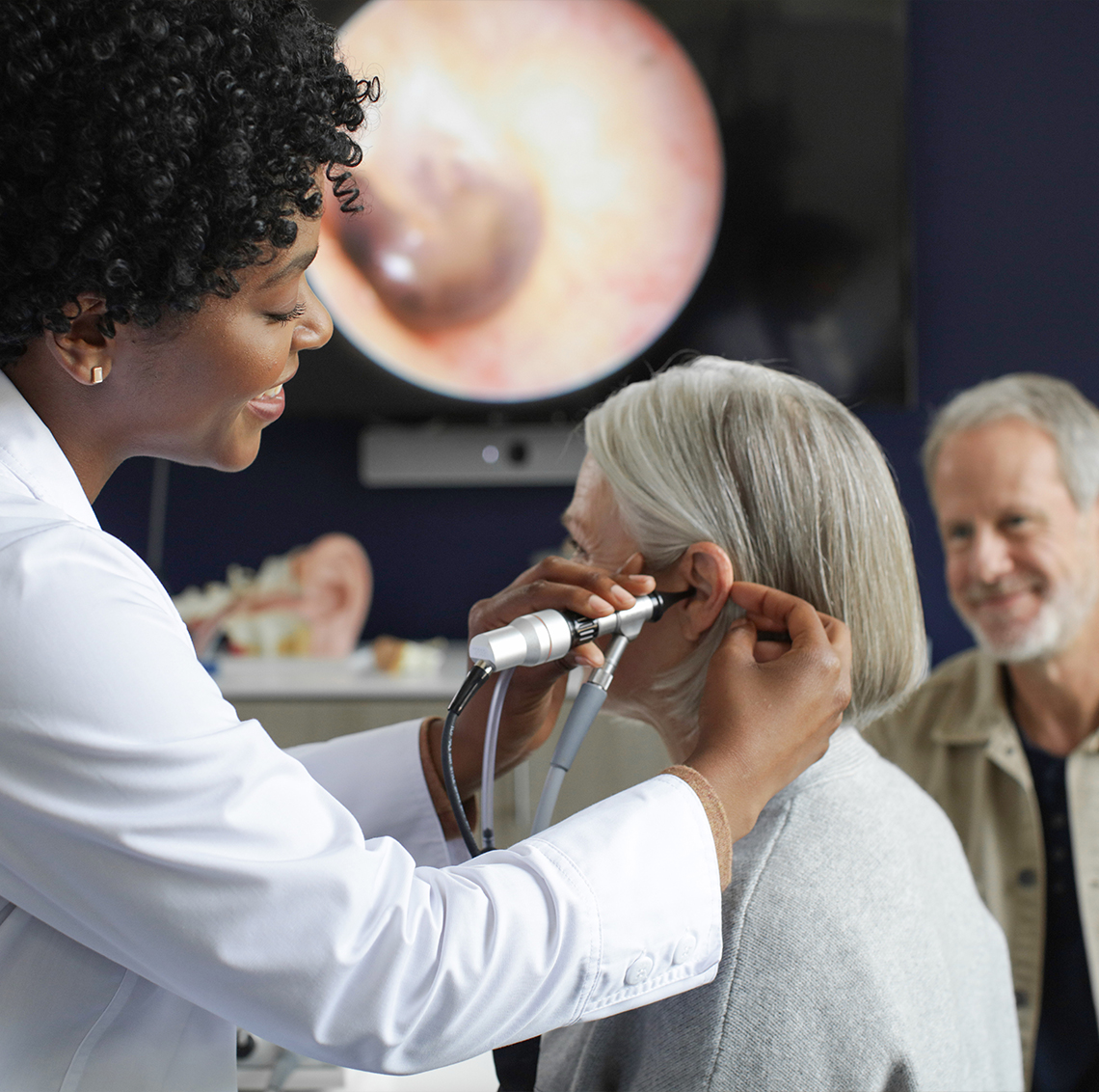 Professional looking into patient's ear