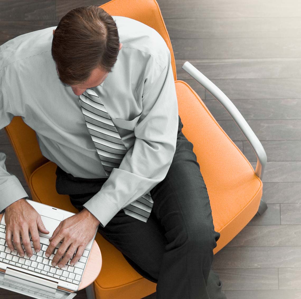 Person sitting in a chair working on a laptop