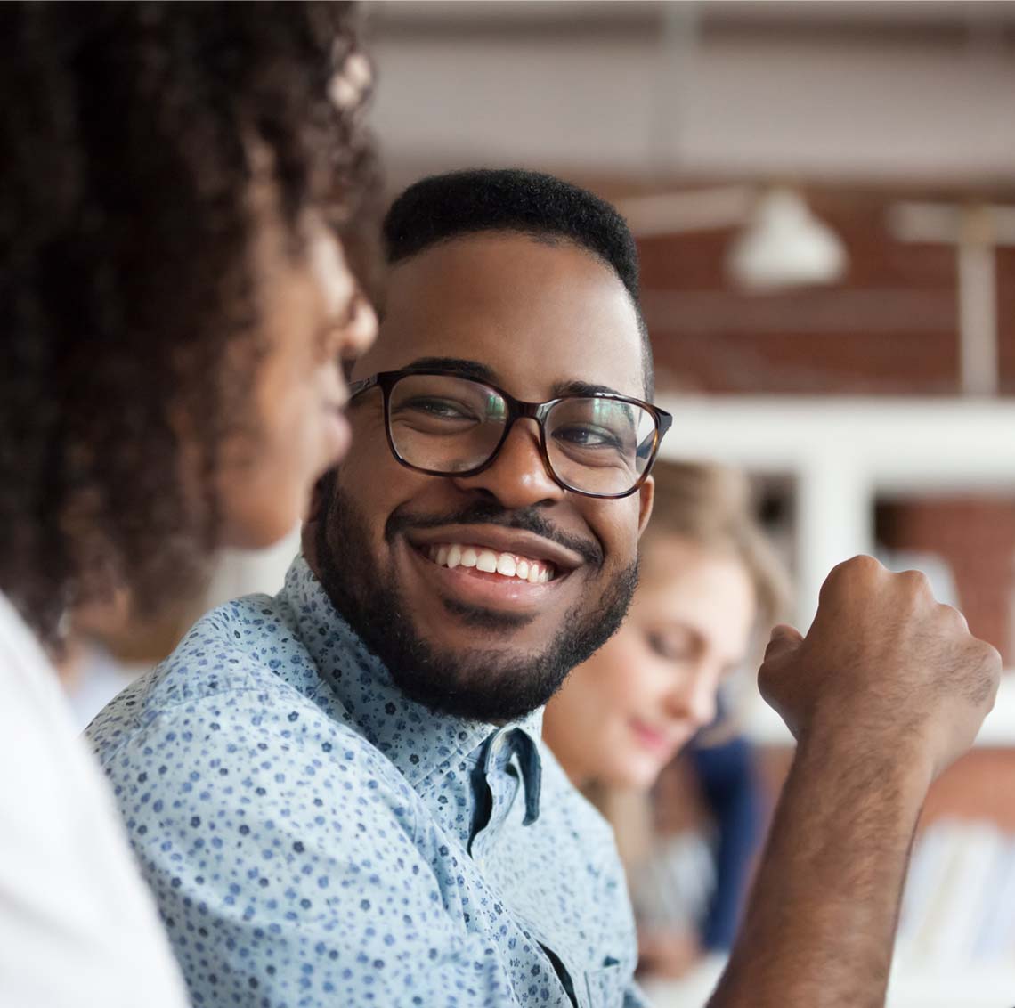 Man with glasses smiling at woman