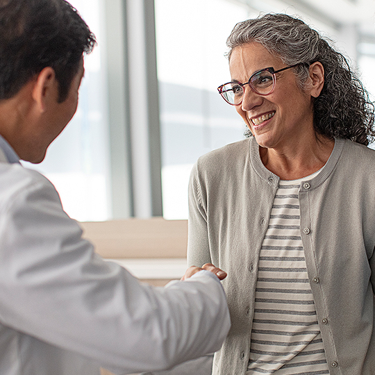 Audiologist shaking a patient's hand.