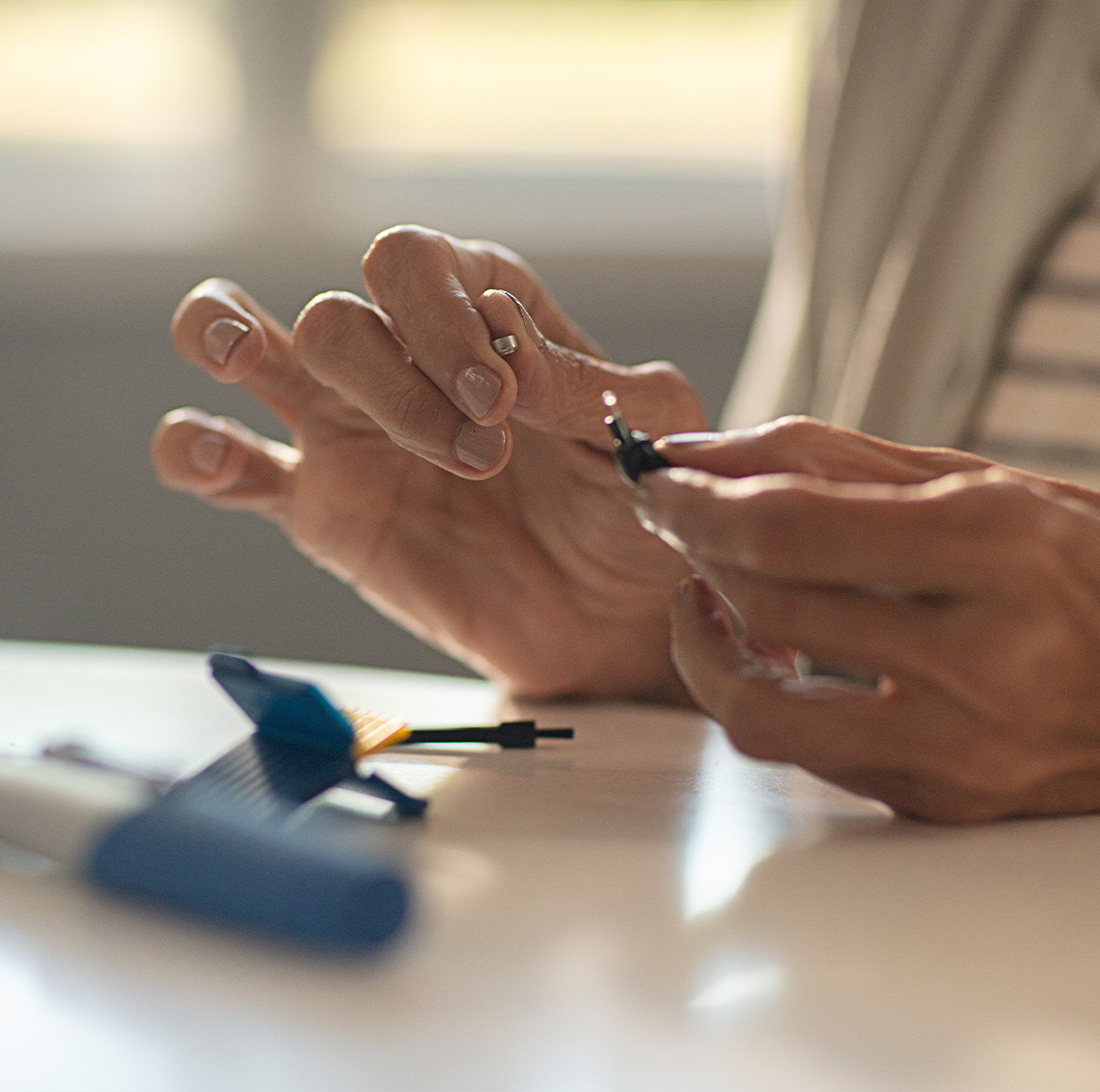 Hearing professional demoing hearing aids to patient