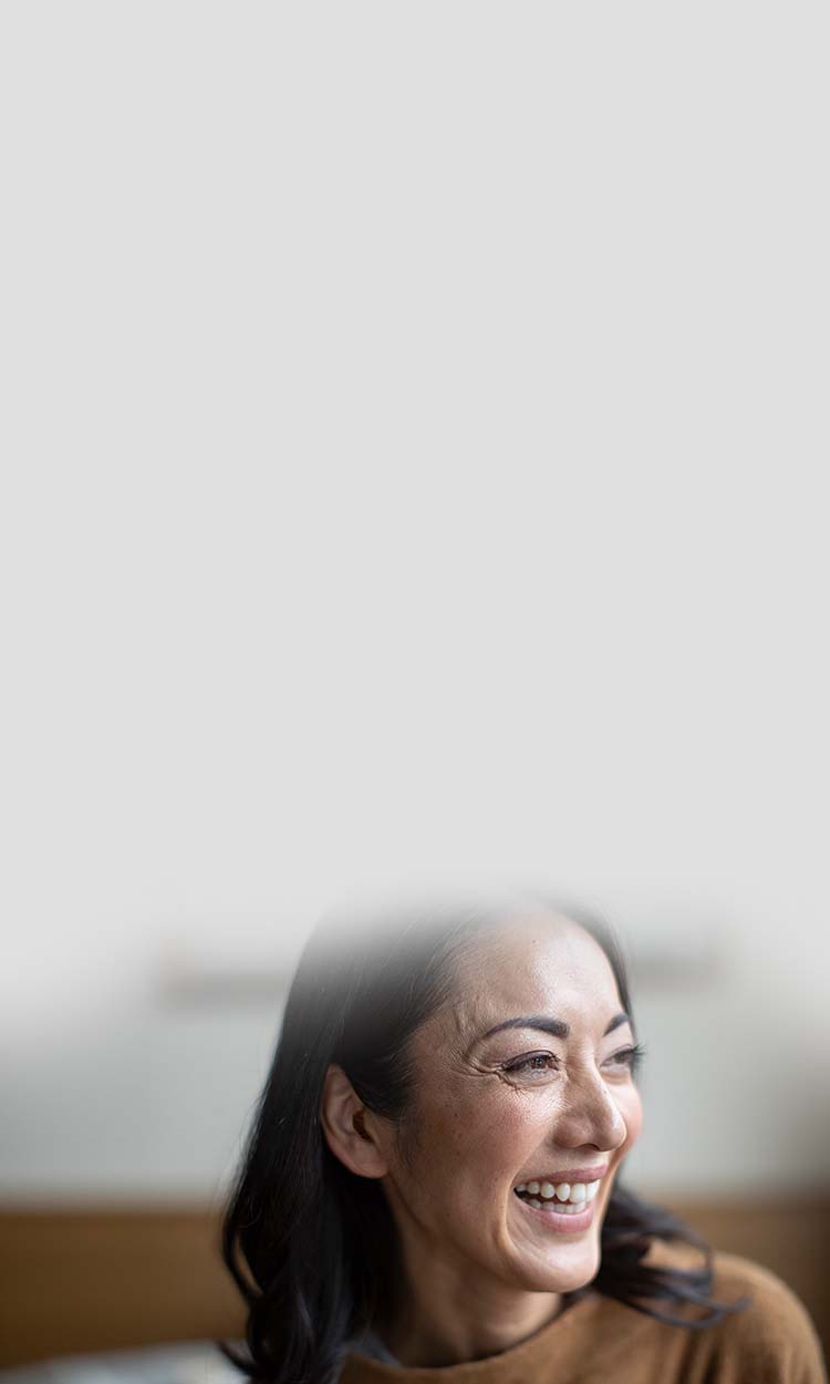 A woman smiling with a hearing aid in her ear