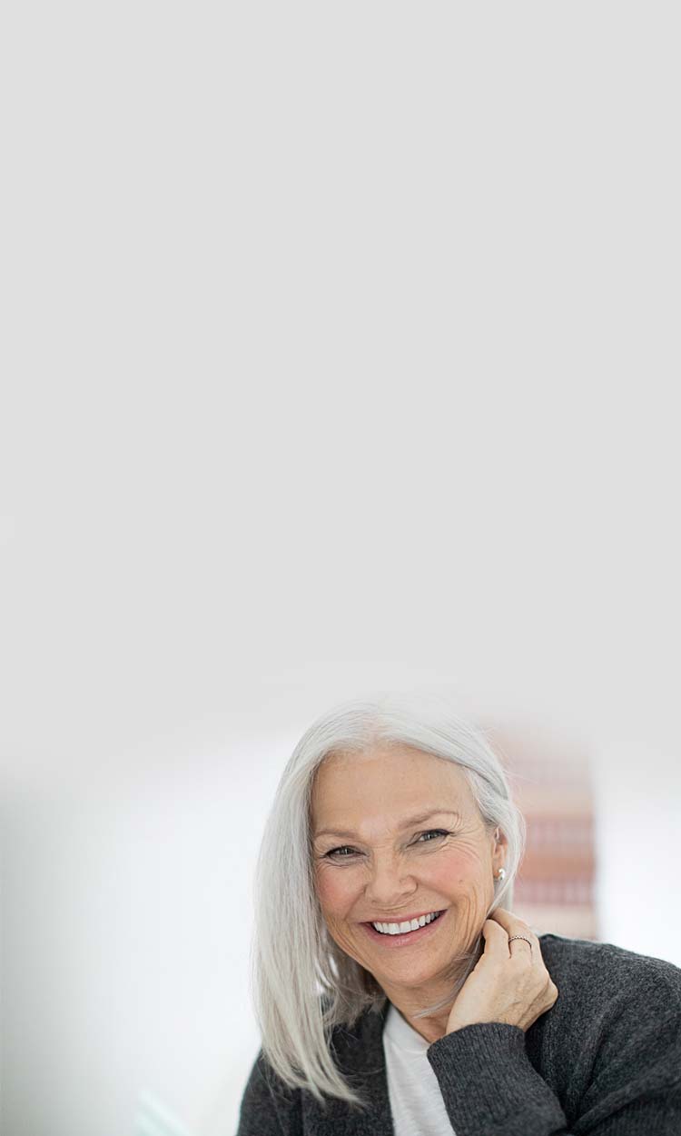 Smiling woman with a hearing aid in her ear