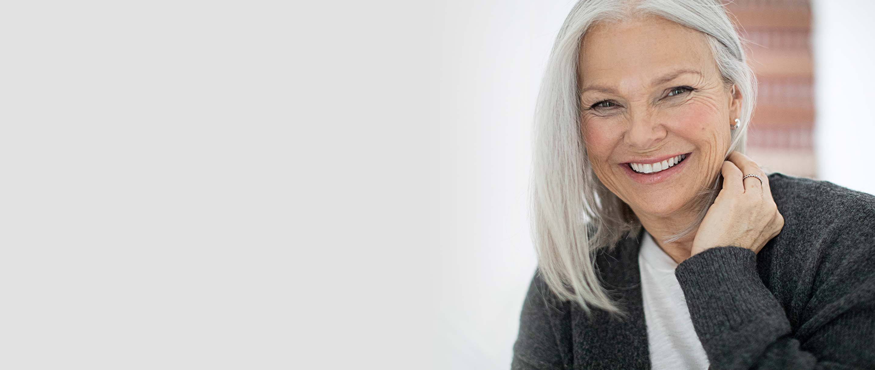 Smiling woman with a hearing aid in her ear